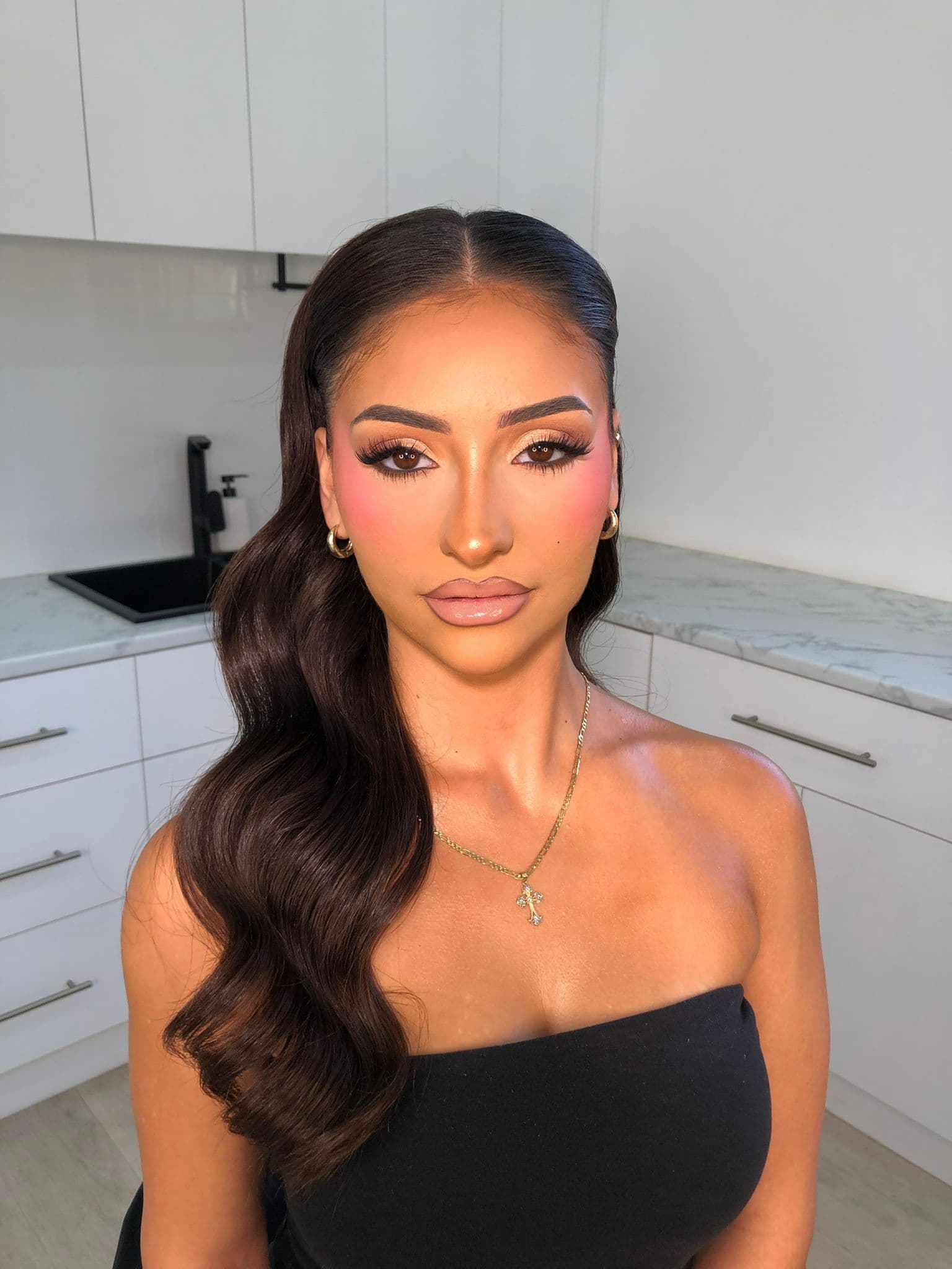 Client wearing soft glam with sculpted waves and rosy blush